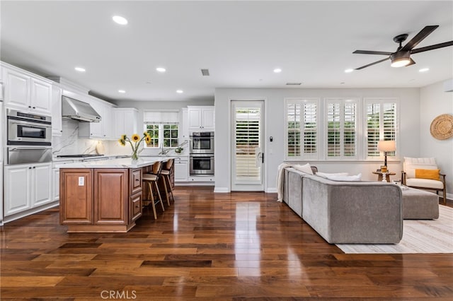 12 John, Ladera Ranch, CA 92694 - kitchen with a warming drawer, extractor fan, dark wood finished floors, a kitchen bar, and open floor plan