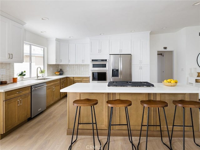 4918 Delacroix Rd, Rancho Palos Verdes, CA 90275 - kitchen with appliances with stainless steel finishes, tasteful backsplash, a breakfast bar area, and white cabinets