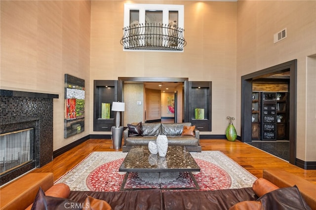 451 W Le Roy Ave, Arcadia, CA 91007 - living room featuring a tile fireplace, wood finished floors, a towering ceiling, and baseboards