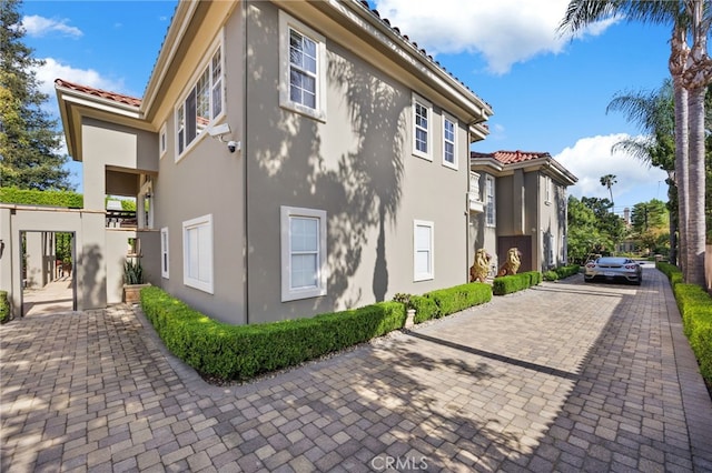 451 W Le Roy Ave, Arcadia, CA 91007 - view of side of property featuring stucco siding, a tile roof, and a surveillance system
