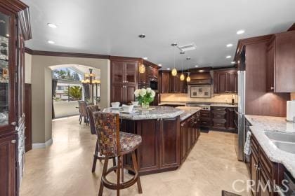 5131 Via Del Valle St, La Verne, CA 91750 - kitchen with a center island, recessed lighting, a kitchen breakfast bar, tasteful backsplash, and light stone countertops
