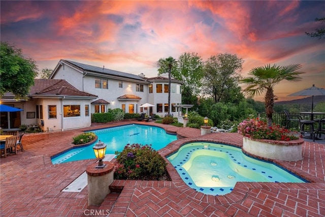 25578 Via Paladar, Valencia, CA 91355 - pool at dusk with a patio, outdoor dining area, and a pool with connected hot tub