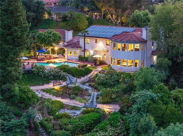 25578 Via Paladar, Valencia, CA 91355 - back of house with stucco siding, an outdoor pool, a chimney, and solar panels