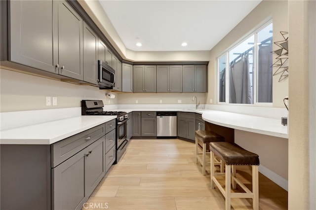 7021 Passons Blvd, Pico Rivera, CA 90660 - kitchen featuring stainless steel appliances, gray cabinets, light wood-style flooring, recessed lighting, and light countertops