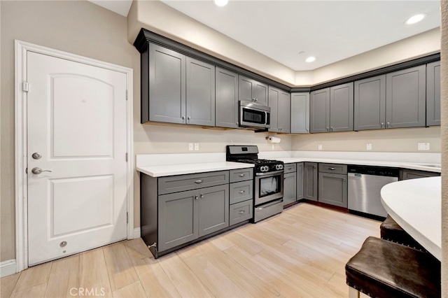 7021 Passons Blvd, Pico Rivera, CA 90660 - kitchen featuring appliances with stainless steel finishes, gray cabinetry, light wood-style floors, light countertops, and recessed lighting