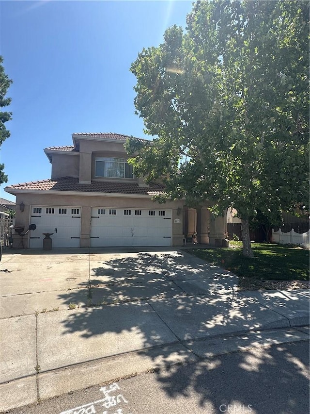 1612 Via Colabria, Gustine, CA 95322 - view of front of home with a tile roof, driveway, stucco siding, and an attached garage