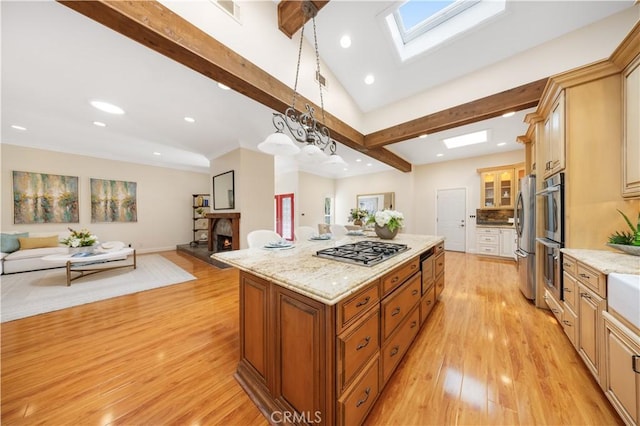 12 Rockrose Way, Irvine, CA 92612 - kitchen with open floor plan, stainless steel appliances, a kitchen island, a skylight, and light wood-style flooring