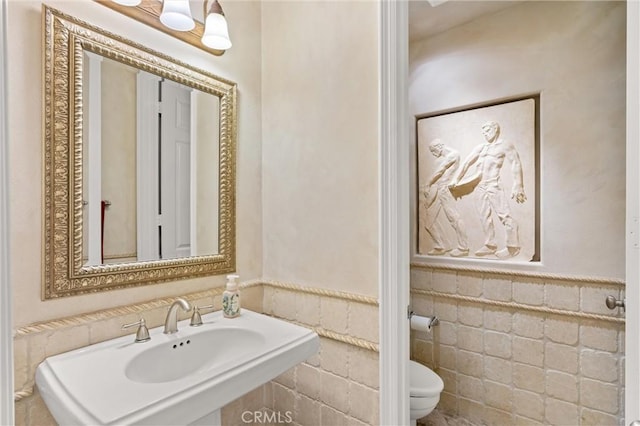 18912 Rockinghorse Ln, Huntington Beach, CA 92648 - bathroom with toilet, wainscoting, tile walls, and a sink