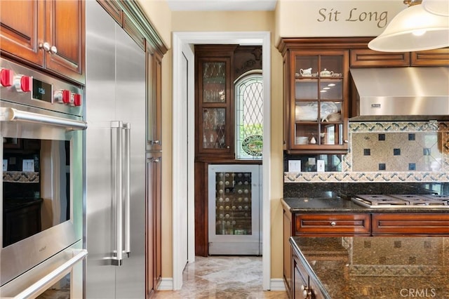 18912 Rockinghorse Ln, Huntington Beach, CA 92648 - kitchen featuring ventilation hood, beverage cooler, stainless steel appliances, decorative backsplash, and dark stone countertops