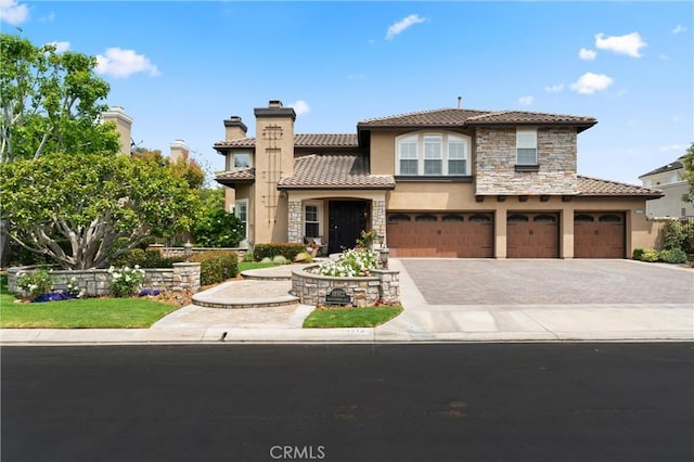 18912 Rockinghorse Ln, Huntington Beach, CA 92648 - view of front of home with stucco siding, stone siding, a tile roof, and driveway