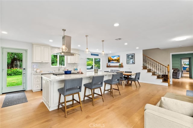 1161 Ravencrest Rd, North Tustin, CA 92705 - kitchen featuring island exhaust hood, healthy amount of natural light, white cabinetry, a large island, and recessed lighting