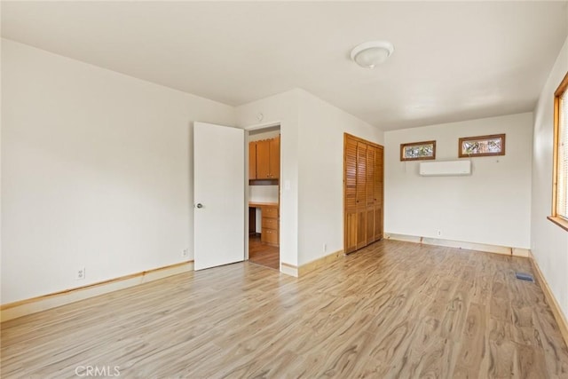 490 Vilas Rd, Chico, CA 95973 - unfurnished room with an AC wall unit, light wood-type flooring, and baseboards