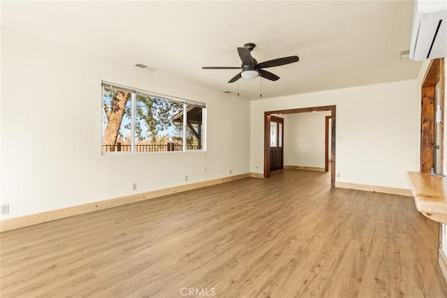 490 Vilas Rd, Chico, CA 95973 - unfurnished living room with light wood-style floors, a wall unit AC, a ceiling fan, and healthy amount of natural light