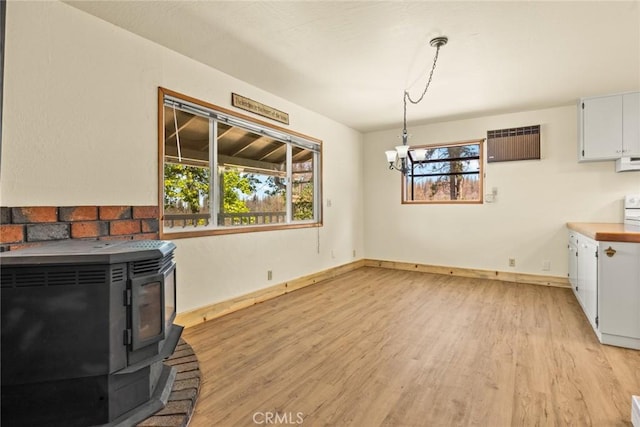 490 Vilas Rd, Chico, CA 95973 - unfurnished living room featuring a wood stove, light wood-type flooring, baseboards, and a chandelier