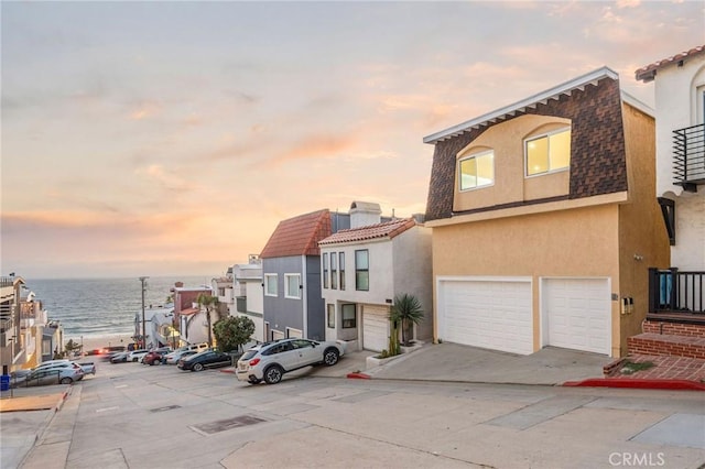 217 43rd St, Manhattan Beach, CA 90266 - view of front facade with stucco siding, an attached garage, a tiled roof, and a water view