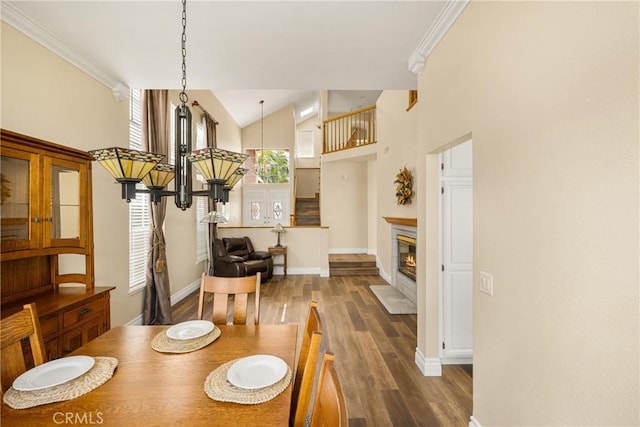 24952 Eaton Ln, Laguna Niguel, CA 92677 - dining area featuring wood finished floors, crown molding, a glass covered fireplace, and high vaulted ceiling