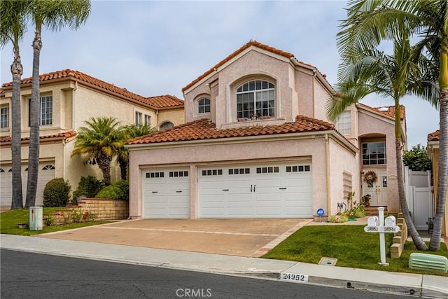 24952 Eaton Ln, Laguna Niguel, CA 92677 - mediterranean / spanish house featuring concrete driveway, a tile roof, stucco siding, and a garage