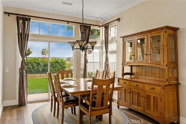 24952 Eaton Ln, Laguna Niguel, CA 92677 - dining space with a chandelier, crown molding, and light wood-style floors