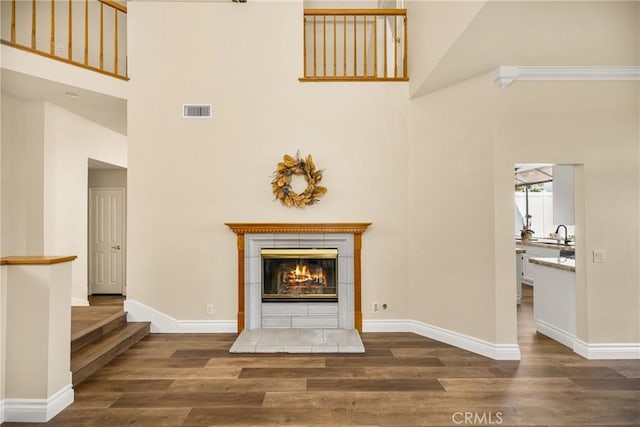 24952 Eaton Ln, Laguna Niguel, CA 92677 - unfurnished living room featuring high vaulted ceiling, wood finished floors, and a tile fireplace
