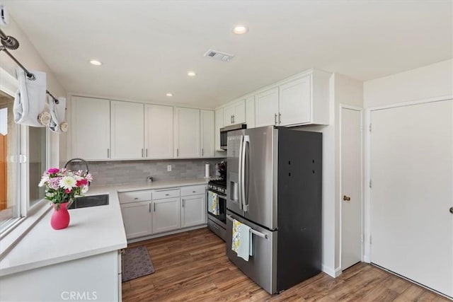 22554 Pico St, Grand Terrace, CA 92313 - kitchen featuring stainless steel appliances, wood finished floors, white cabinetry, light countertops, and a sink