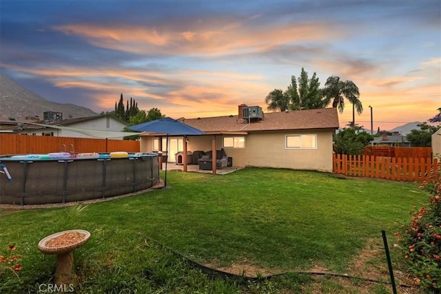 22554 Pico St, Grand Terrace, CA 92313 - back of property at dusk featuring stucco siding, central air condition unit, and a patio