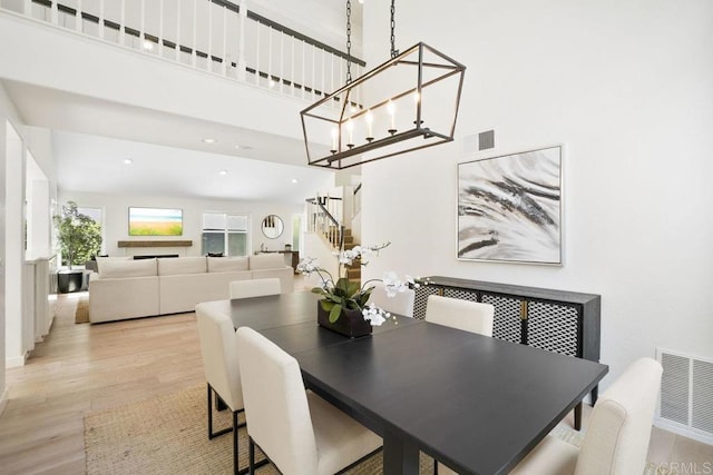 5233 Belardo Dr, San Diego, CA 92124 - dining room with light wood finished floors, a chandelier, a high ceiling, and recessed lighting