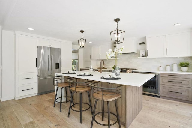 5233 Belardo Dr, San Diego, CA 92124 - kitchen featuring high end fridge, wine cooler, an island with sink, light countertops, and a breakfast bar