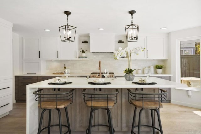 5233 Belardo Dr, San Diego, CA 92124 - kitchen with tasteful backsplash, white cabinets, light countertops, a breakfast bar area, and recessed lighting