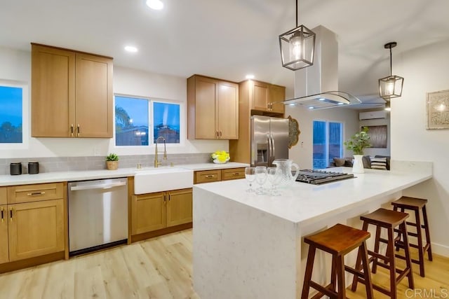 3776 Enero Ct, San Diego, CA 92154 - kitchen featuring stainless steel appliances, a sink, a kitchen bar, light wood-style flooring, and a wall mounted air conditioner