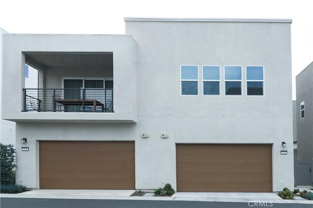 173 Biome, Irvine, CA 92618 - view of front of home featuring a balcony, stucco siding, and an attached garage