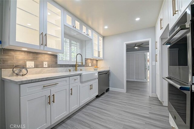 11471 Gill Dr, Garden Grove, CA 92841 - kitchen with appliances with stainless steel finishes, ceiling fan, backsplash, recessed lighting, and white cabinetry