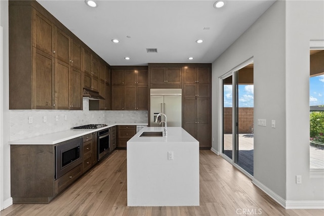 20748 Beech Cir, Porter Ranch, CA 91311 - kitchen featuring built in appliances, light wood-type flooring, light countertops, tasteful backsplash, and recessed lighting