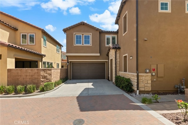 20748 Beech Cir, Porter Ranch, CA 91311 - view of front of house featuring stucco siding, decorative driveway, an attached garage, stone siding, and a tile roof