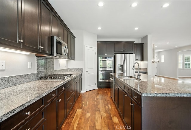 35414 Laurel Tree Ct, Winchester, CA 92596 - kitchen with appliances with stainless steel finishes, wood finished floors, light stone countertops, a kitchen island with sink, and recessed lighting