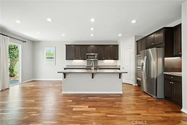 35414 Laurel Tree Ct, Winchester, CA 92596 - kitchen with appliances with stainless steel finishes, a breakfast bar, light stone countertops, dark wood-type flooring, and dark brown cabinets