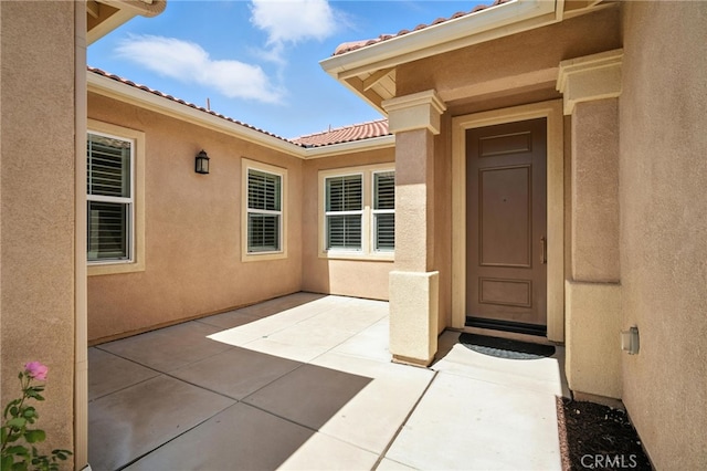 35414 Laurel Tree Ct, Winchester, CA 92596 - view of exterior entry with a patio, stucco siding, and a tile roof