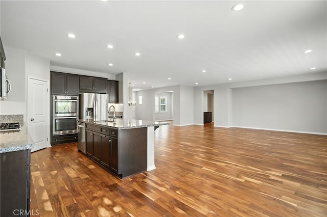 35414 Laurel Tree Ct, Winchester, CA 92596 - kitchen featuring stainless steel appliances, open floor plan, recessed lighting, wood finished floors, and light stone countertops