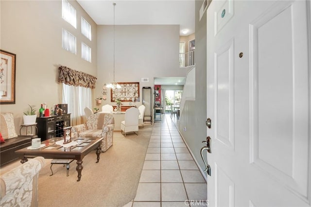 2825 W Newgrove St, Lancaster, CA 93536 - foyer featuring a towering ceiling, light tile patterned floors, light carpet, a chandelier, and baseboards