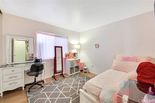 2825 W Newgrove St, Lancaster, CA 93536 - bedroom featuring a desk, wood finished floors, and baseboards