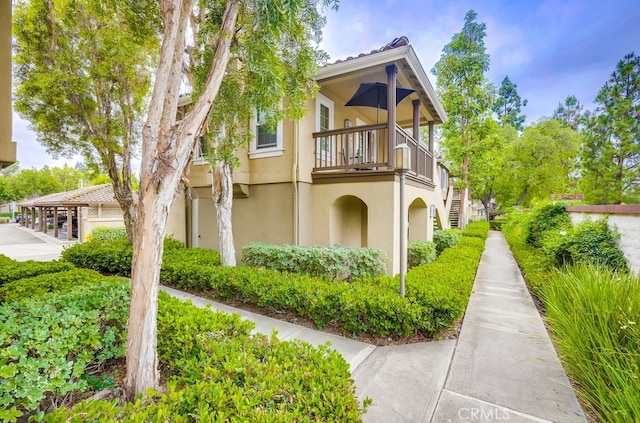 253 Gallery Way, Tustin, CA 92782 - view of side of property featuring stucco siding, stairs, and a balcony