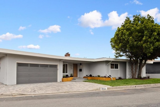 4252 Don Jose Dr, Los Angeles, CA 90008 - ranch-style house featuring stucco siding, an attached garage, a chimney, and decorative driveway