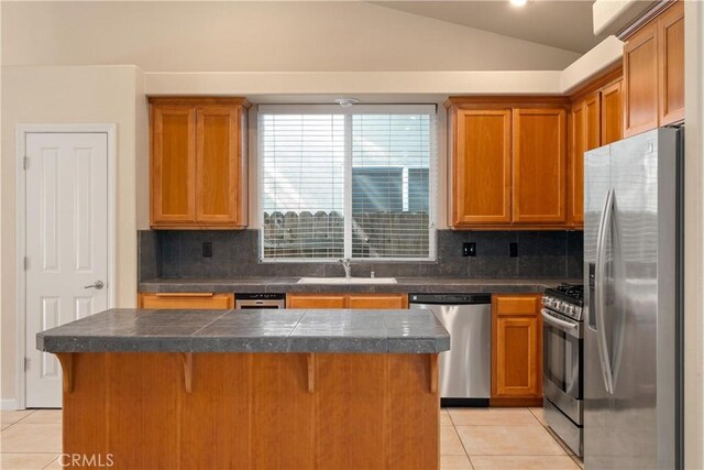 1033 Raven Ln, Chico, CA 95926 - kitchen with appliances with stainless steel finishes, light tile patterned flooring, vaulted ceiling, a sink, and tasteful backsplash