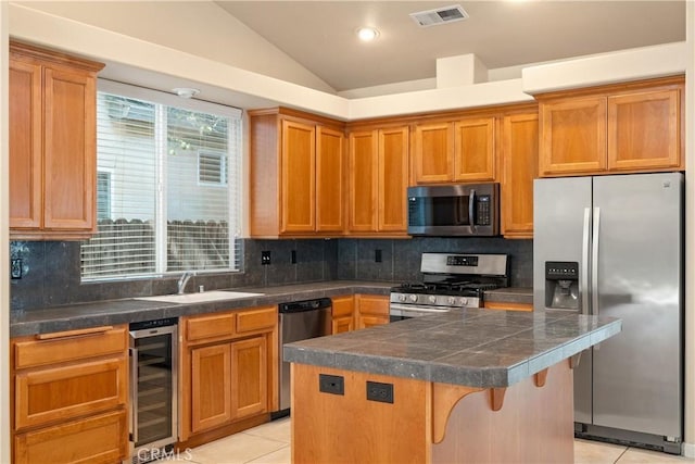 1033 Raven Ln, Chico, CA 95926 - kitchen featuring appliances with stainless steel finishes, beverage cooler, a sink, light tile patterned floors, and a center island