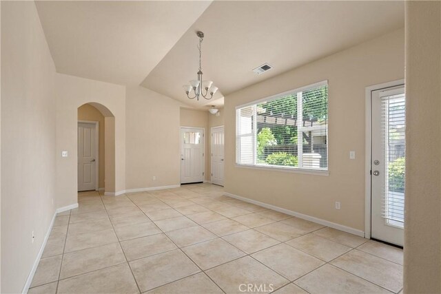 1033 Raven Ln, Chico, CA 95926 - unfurnished dining area with arched walkways, a chandelier, light tile patterned flooring, and baseboards