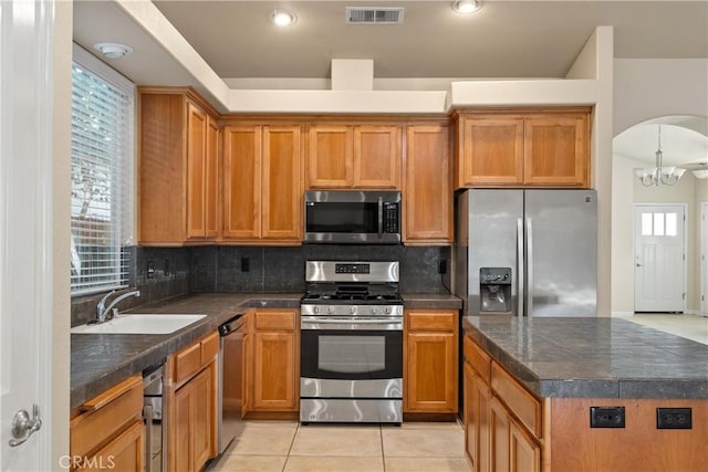 1033 Raven Ln, Chico, CA 95926 - kitchen with appliances with stainless steel finishes, a sink, tasteful backsplash, and light tile patterned floors