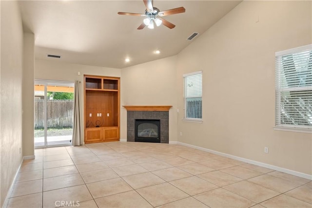 1033 Raven Ln, Chico, CA 95926 - unfurnished living room featuring a tiled fireplace, ceiling fan, light tile patterned flooring, high vaulted ceiling, and baseboards