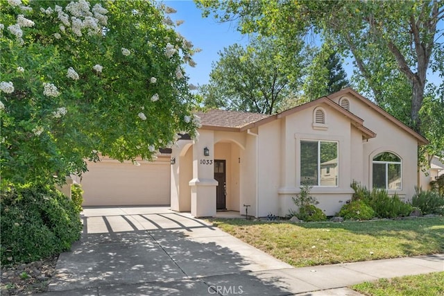 1033 Raven Ln, Chico, CA 95926 - view of front facade featuring stucco siding, concrete driveway, a garage, a front lawn, and roof with shingles