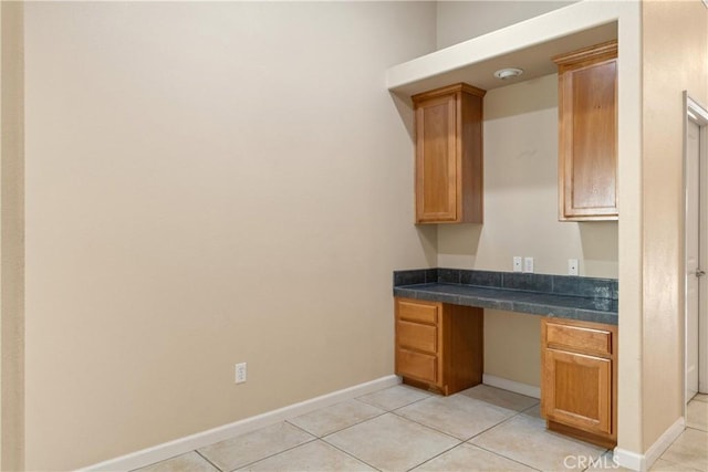 1033 Raven Ln, Chico, CA 95926 - kitchen with dark countertops, light tile patterned flooring, brown cabinets, and baseboards