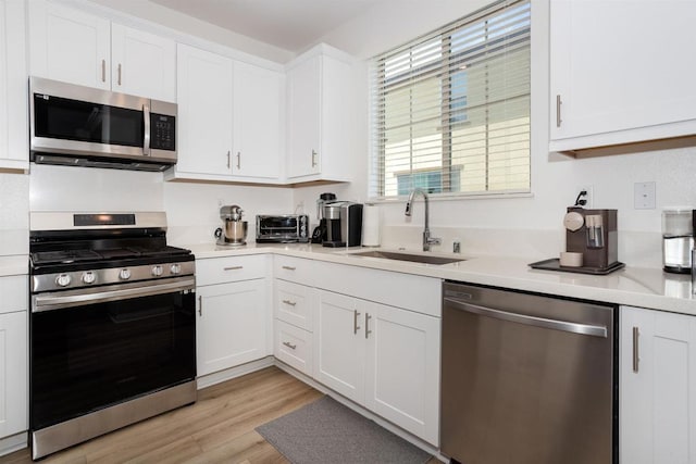 1807 Mesquite Way, Oceanside, CA 92056 - kitchen with appliances with stainless steel finishes, a sink, white cabinetry, and light countertops