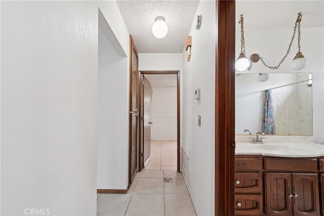 14676 Poplar St, Hesperia, CA 92345 - hallway with a textured ceiling, light tile patterned floors, baseboards, and a sink